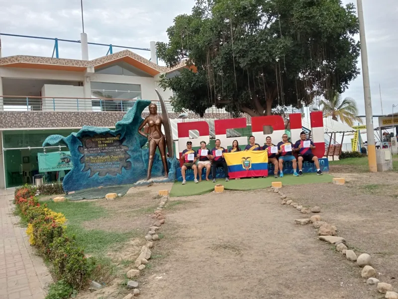 Grupo de viajeros junto al monumento de Perú en Zorritos, Tumbes