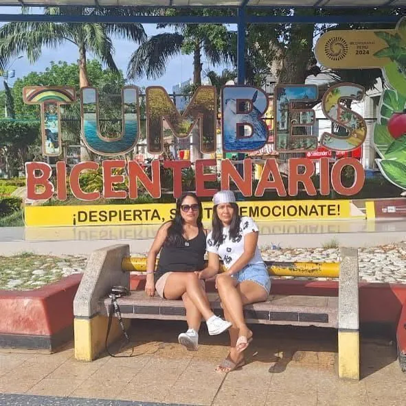 Visitantes junto al letrero turístico de Tumbes